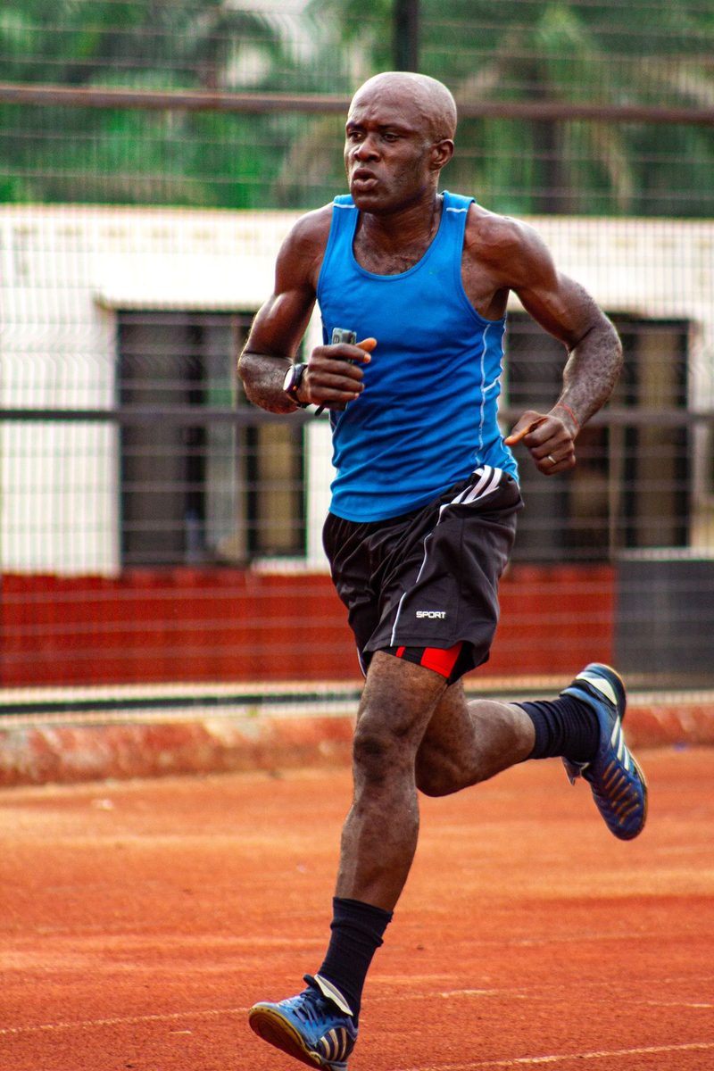 Man running on an outdoor athletics track.
